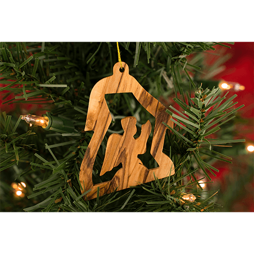 olive wood praying angel seasonal ornament hanging on a christmas tree with lights