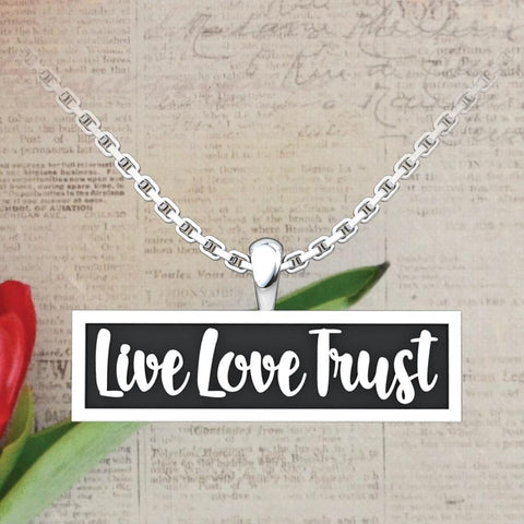 Live Love Trust Sterling Silver Pendant on a newspaper background