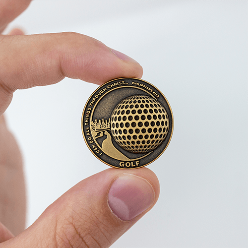 Front of Golf Team Antique Gold Plated Sports Coin in between fingers