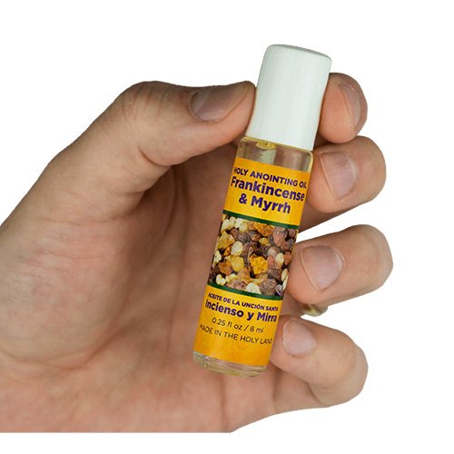 view of frankincense & myrrh scented anointing oil being held in a human hand