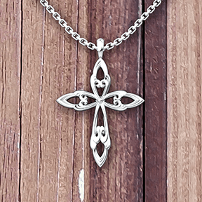 Leaf Cross Sterling Necklace with 18 inch chain on a wooden table