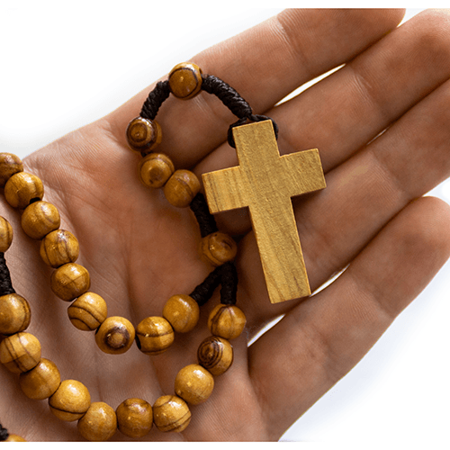 bulk olive wood rosary, cord style pack of 10, single rosary shown inside a palm