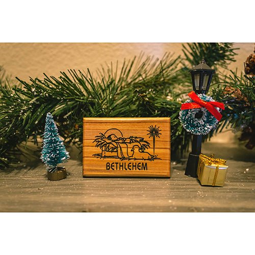 Bethlehem manger and christmas star holy land olive wood magnet amid garland and seasonal décor