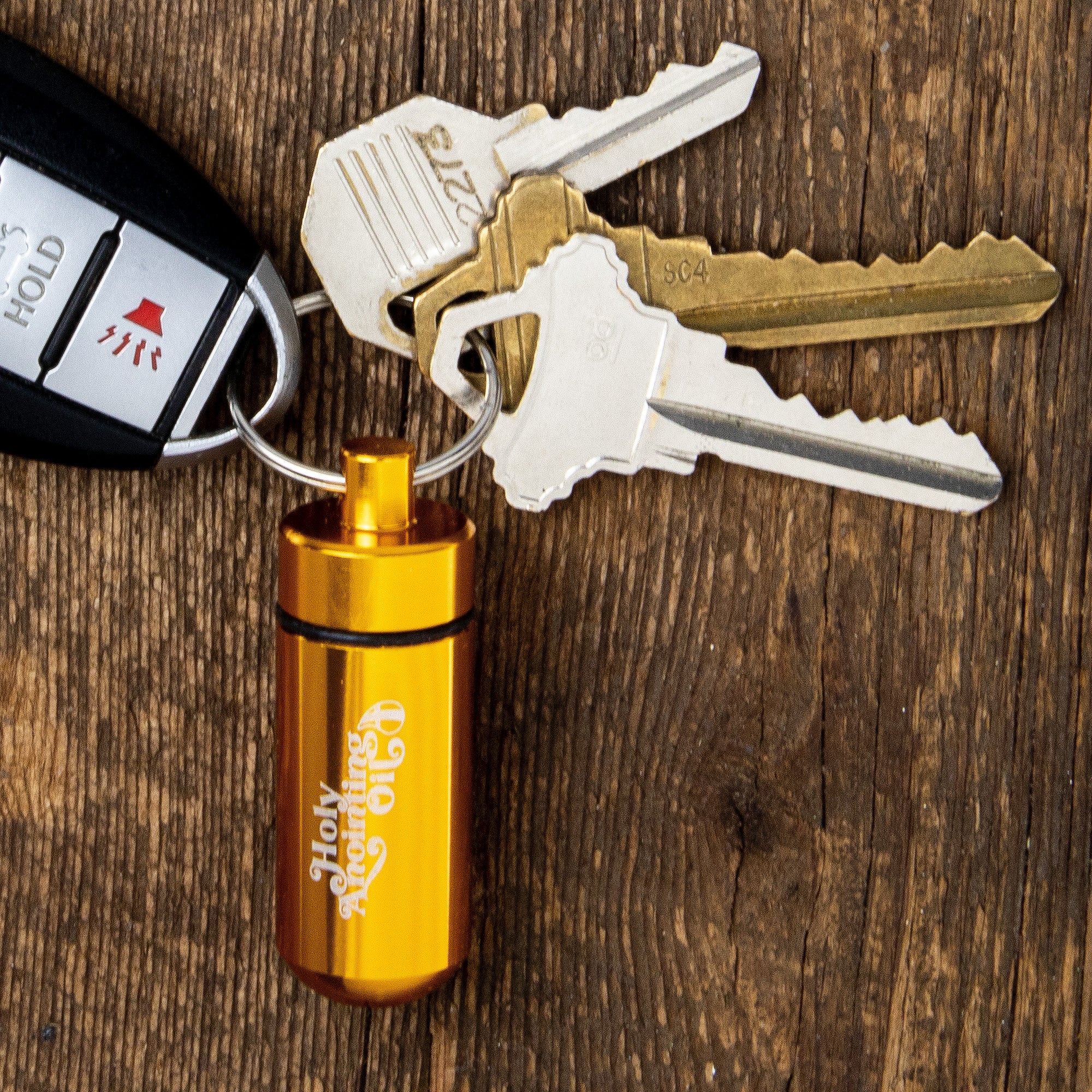 Oil Vial Keyring showing keyring vial holder with keys on wood background