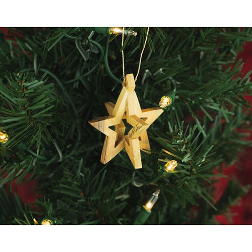 wooden hanging bethlehem star ornament on a christmas tree with lights