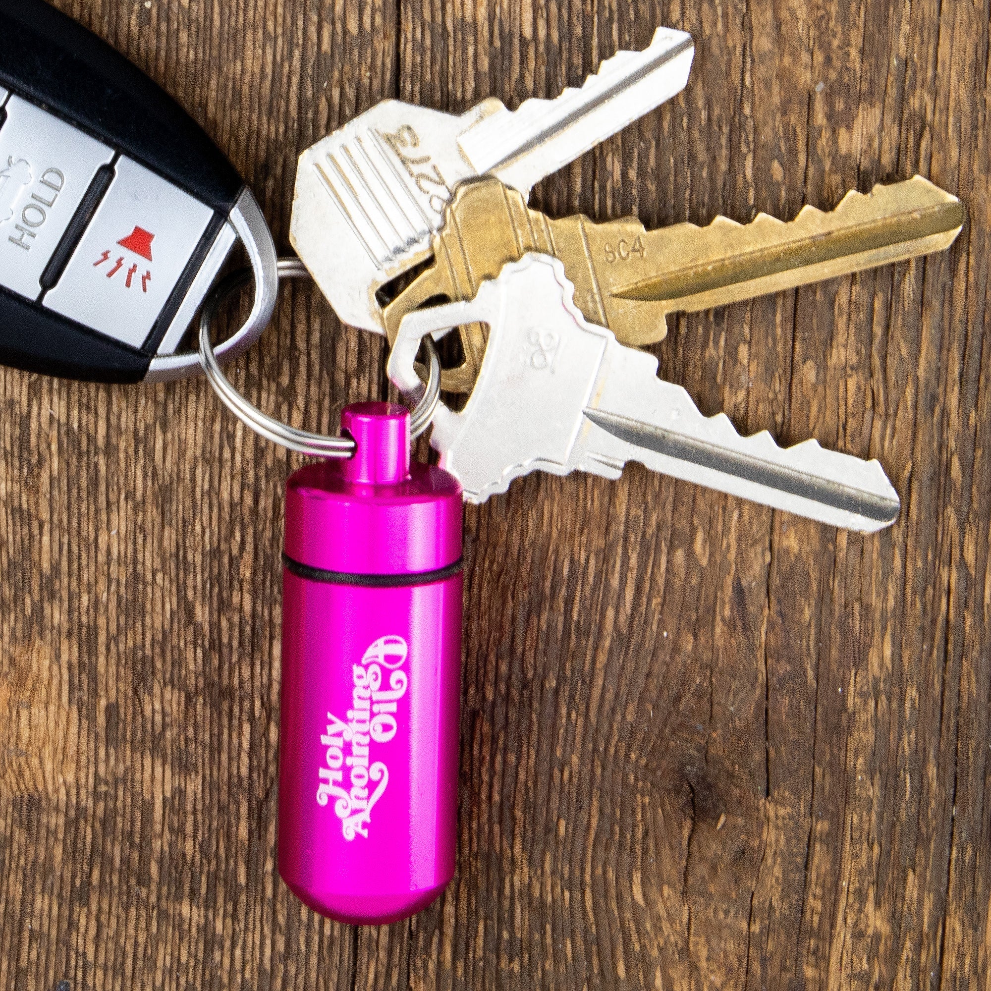 Oil Vial Keyring showing keyring vial holder with keys on wood background