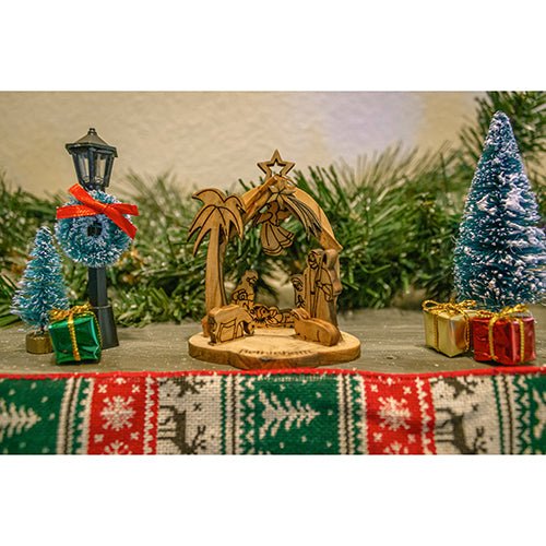 picture of nativity manger ornament amid garland and seasonal decorations
