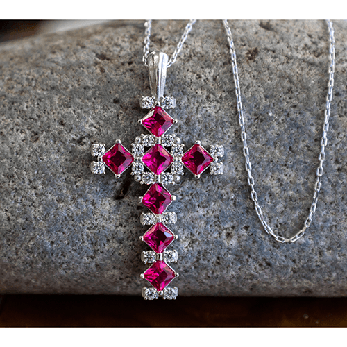 July Ruby Birthstone Cross Pendant - With 18" Sterling Silver Chain on a stone