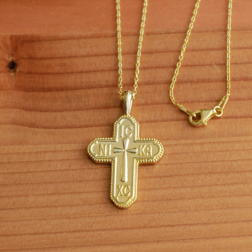 Jesus Christ the King (IC XC NIKA) Gold-Plated Sterling Silver Pendant and 18" Chain on a wooden table