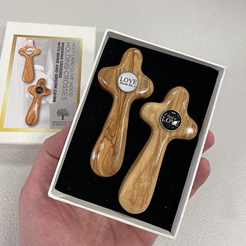 A hand holding the protective box showing the inside view for the olive wood wedding cross gift set of two unity crosses