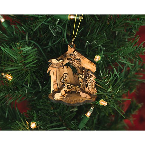 wooden hanging nativity grotto ornament on a christmas tree with lights