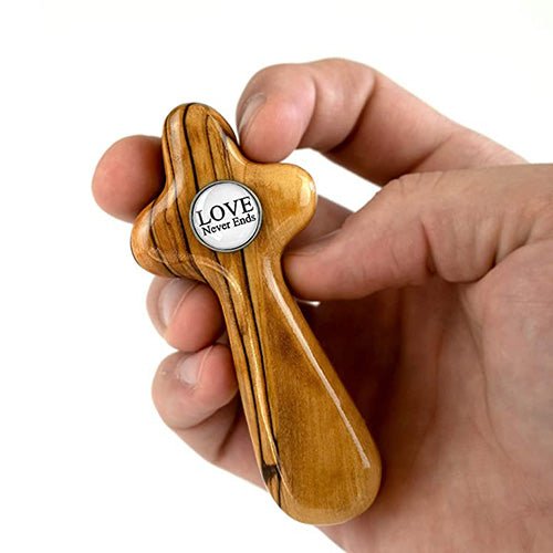 Hand holding the bride cross from the the olive wood wedding cross gift set