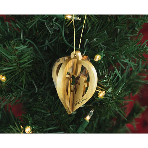 wooden hanging heart nativity ornament on a christmas tree with lights