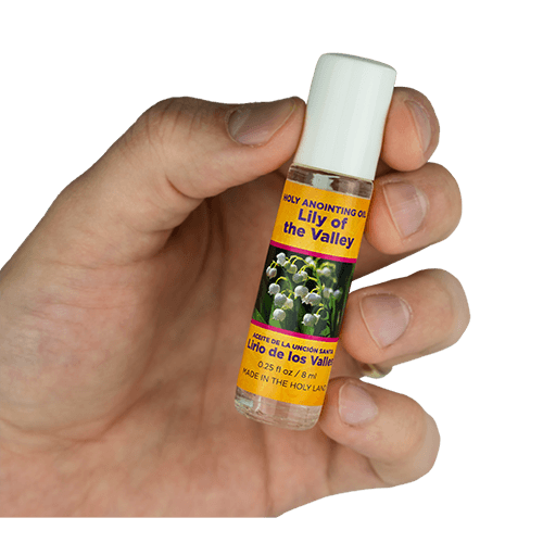view of lily of the valley scented anointing oil being held in a human hand