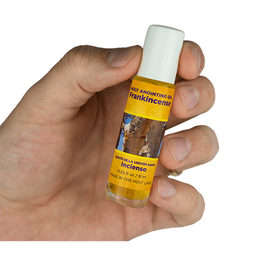view of frankincense scented anointing oil being held in a human hand